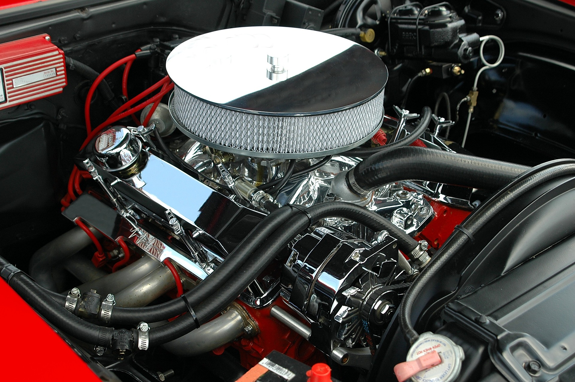 A picture inside the open hood of a 50s car. You can see that the engine is relatively simple where you can easily see all the components, especially compared to the Prius engine